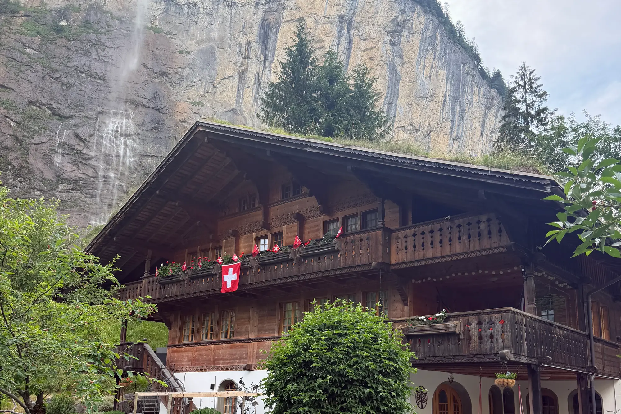 Lauterbrunnen valley floor with the Staubbach Falls dropping from sheer cliffs, Bernese Oberland, Switzerland